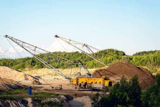Large dragline excavator working in an open‑pit mine under clear blue sky