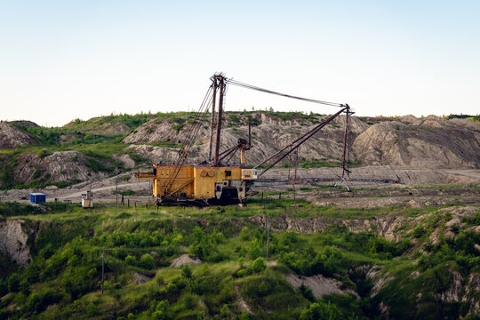 Large dragline excavator working in an open‑pit mine under clear blue sky