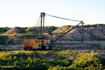 Fototapeta premium Large dragline excavator working in an open‑pit mine under clear blue sky
