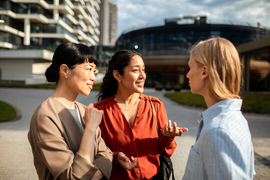 Three businesswomen talking outdoors in modern city