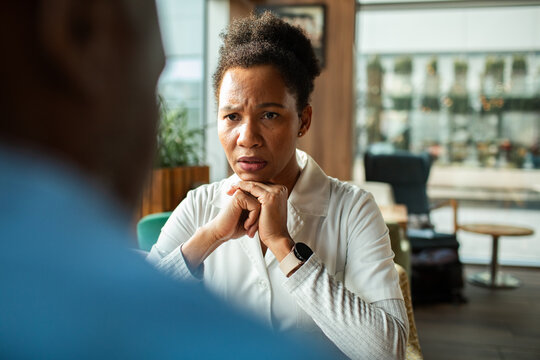 Concerned female doctor listening to patient in hospital waiting area