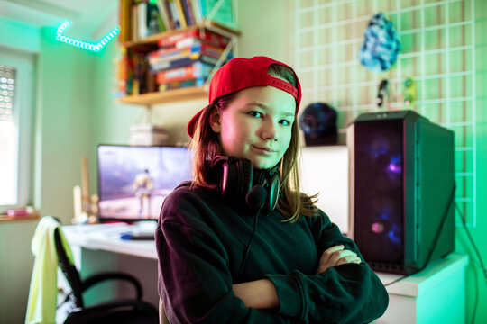 Confident teenage gamer girl in bedroom gaming setup