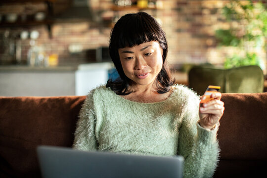 Woman shopping online at home with credit card