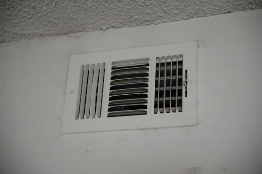 an open air vent on a white wall with a stucco ceiling above