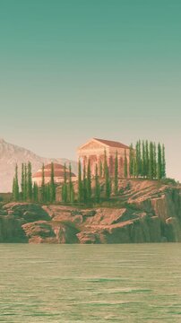 A structure sits on a rocky area next to water. There are green trees around the building. Mountains rise in the background under a clear sky.