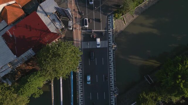 a small bridge in Surabaya Genteng district, aerial top down reverse view following traffic