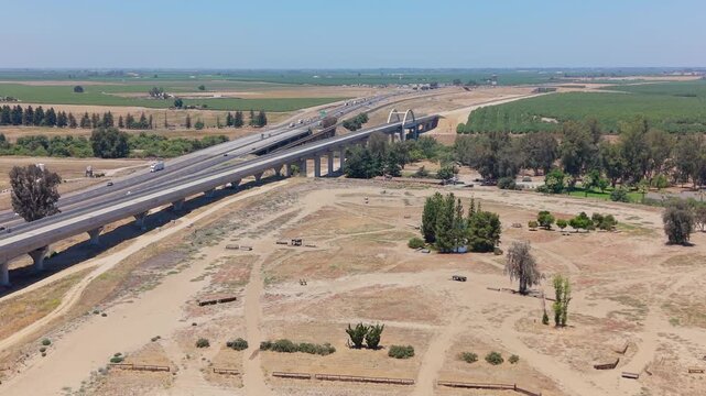 Forward Moving Aerial Drone Shot Over California High Speed Rail Construction With San Joaquin River Viaduct Overpass Freeway and Farmland