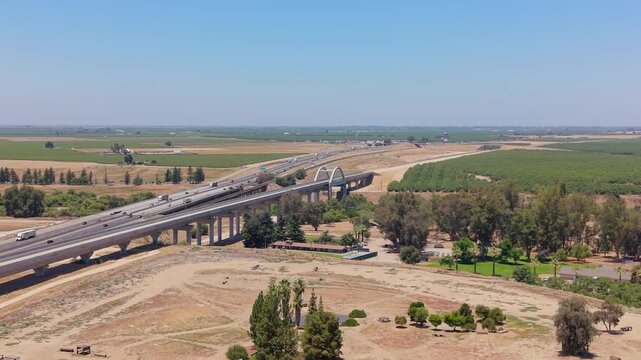 Reversing and Panning Aerial Drone Shot Right to Left Over California High Speed Rail Construction With San Joaquin River Viaduct Overpass Freeway and Farmland