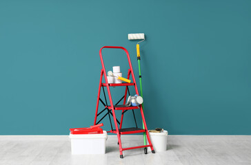Painting supplies with ladder against teal wall © Pixel-Shot