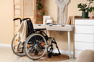 Fototapeta premium Wheelchair next to desk in cozy home interior