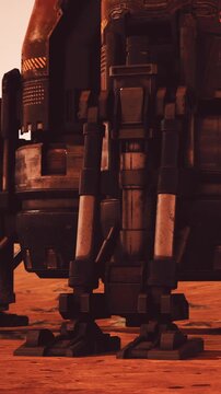 The scene shows the legs of a robot standing on a red surface. The background has a metallic structure with industrial details. Sunlight casts shadows on the ground.