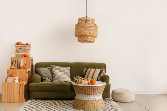 Cozy sofa, coffee table and shelving unit in interior of living room