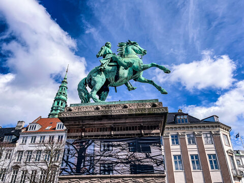 Equestrian statue of Bishop Absalon in Hojbro Plads square against a blue sky with clouds, Copenhagen, Denmark