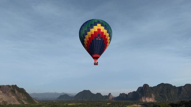 Vang Vieng , Laos - 07/02/2025:Aerial drone footage of colorful hot air balloons flying above the scenic landscape of Vang Vieng in Laos during sunrise
