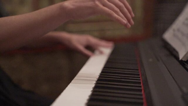 Hands Playing Piano in Warm Indoor Light