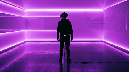 Fototapeta premium Silhouette of a person walking in a futuristic neon-lit corridor.
