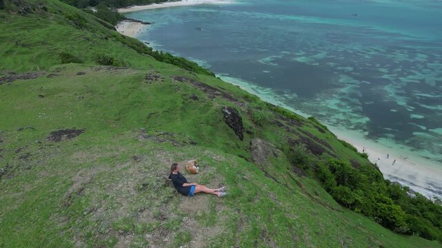 Caucasian Woman Contemplating Stormy Bay, Sits With Dog On Ridge Under Brooding Clouds, Dramatic Ocean Tones And Distant Islands Create Reflective Mood And Wanderlust Companionship,Lombok