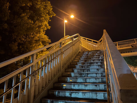 街灯に照らされた歩道橋の階段、深夜の静寂を感じる都会の夜景 ホラー素材にも