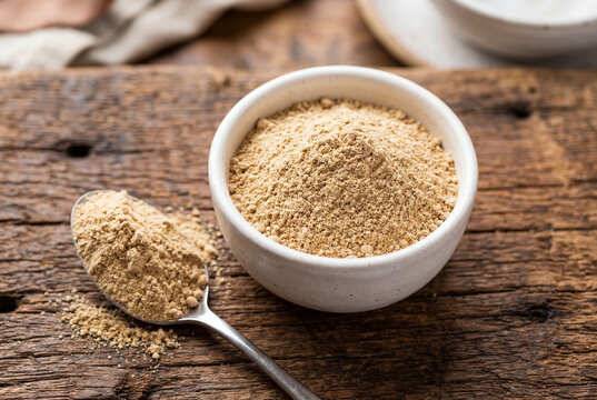 Natural maca root powder in white ceramic bowl on rustic wood