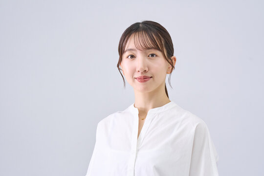Young Japanese Woman with Serious Expression in White Top, Studio Portrait