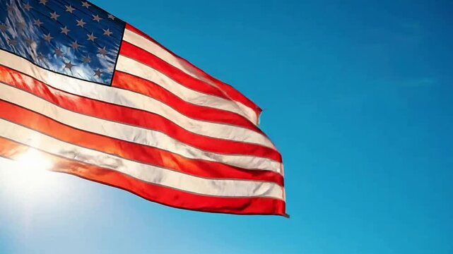 American flag waving in the breeze against blue sky