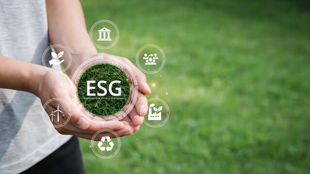 Person holding ESG concept with sustainability icons in green field
