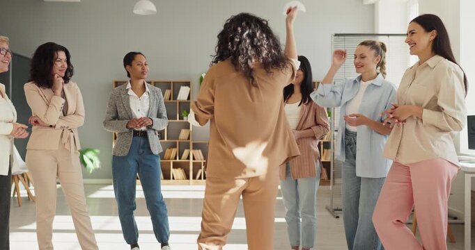 Women team applause in meeting coaching teamwork success. Colleagues gather in a bright office, share high fives, support a workshop leader, and celebrate goals. Key concept is women teamwork.