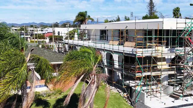 Residential House Renovation with Scaffolding and Palm Trees in Gold Coast