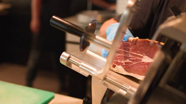 Professional Chef Slicing Cured Meat with Electric Deli Slicer