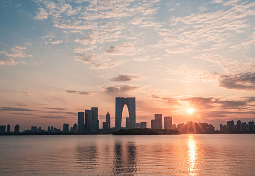 Evening skyline of Suzhou Gate of the Orient at dusk over lake.