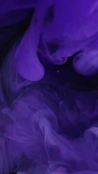 Vertical video. Ink water. Neon splash. Blur purple lilac color paint fluid wet vapor smoke liquid swirling on abstract dark black foggy background.