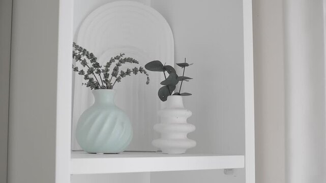 Decorative vases with plants on a simple shelf