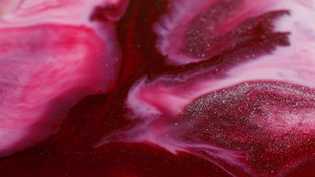 Paint splash. Stream texture. Defocused red purple pink color glitter water splatter spreading on abstract vibrant acrylic background.