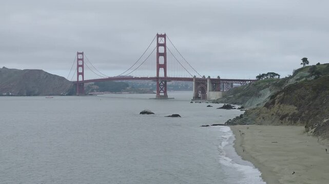 Golden Gate Bridge From Baker Beach On Overcast Day - Drone Tracking Shot