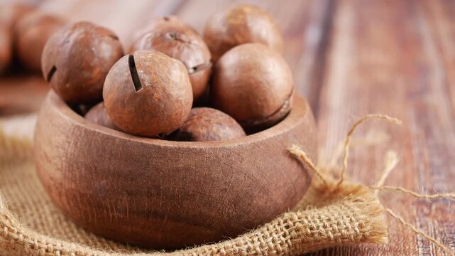 Macadamia nuts in wooden bowl on table