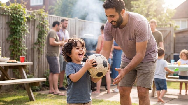 Joyful toddler holds soccer ball high with dad at National Grilling Month backyard gathering for family lifestyle marketing campaigns.