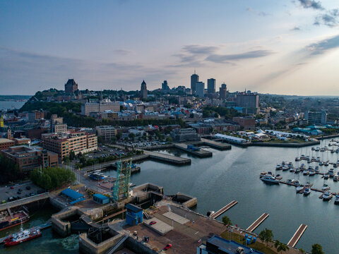 Aerial view of the historic Quebec City skyline, the iconic Chateau Frontenac, and the bustling port marina with numerous boats docked along the Saint Lawrence River in Quebec, Quebec, Canada.