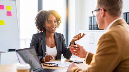 Confident African American businesswoman engaging in a lively discussion or interview in a bright...