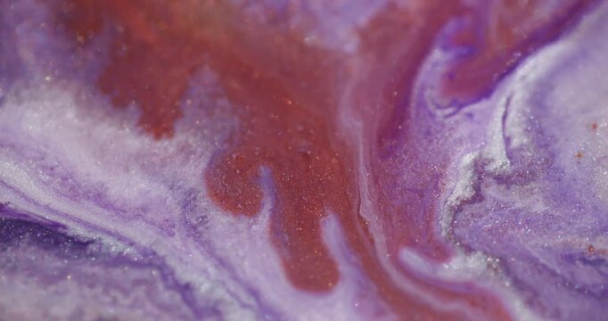 Paint blend. Sparkling texture. Red orange trickle drop flow on blur purple acrylic abstract background emulsion with color pigment.