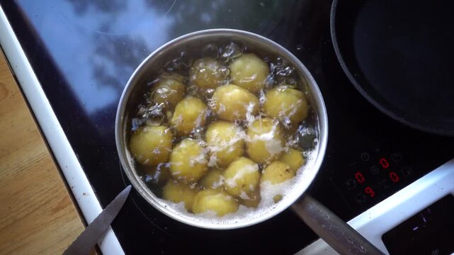 Stockholm, Sweden Fresh potatoes boiling in a pot of water on an induction stovetop.  