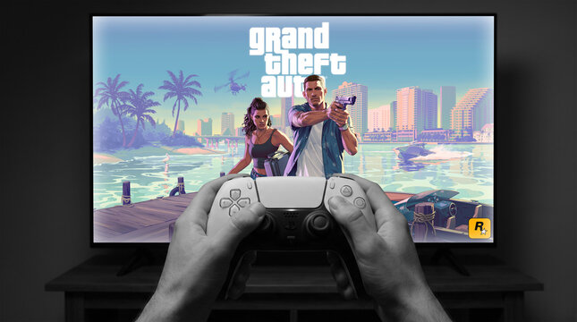 Grand Theft Auto VI artwork on TV screen with PS5 DualSense controller showing Jason and Lucia on Florida waterfront
