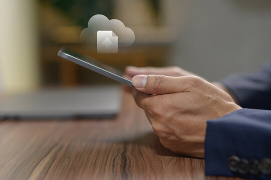 Businessman Using Smartphone with Cloud Data Icon in a Modern Workspace