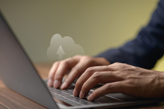 Businessperson Typing on Laptop with Cloud Computing Concept in Background