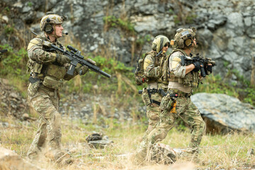 Fototapeta premium Special operations team advances through rugged terrain during a tactical patrol exercise