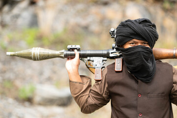 Fototapeta premium Armed insurgent carrying a rocket launcher during a military conflict simulation