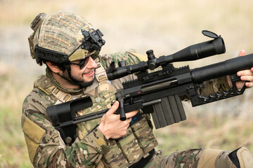Fototapeta premium Military marksman aiming through a scoped rifle during tactical training exercise