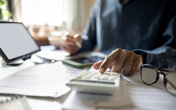 close up shot, man hand using calculator, accountant working in office with financial report, business document, calculate monthly expenses and budget for make business plan