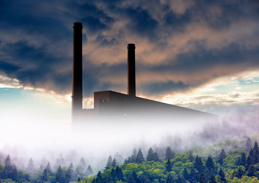 Smoke plume from ower plant emitting greenhouse gas into the atmosphere on forest trees background
