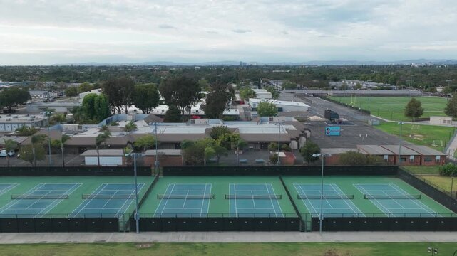 Wide aerial dolly shot of tennis courts at a high school in Southern California. 4K