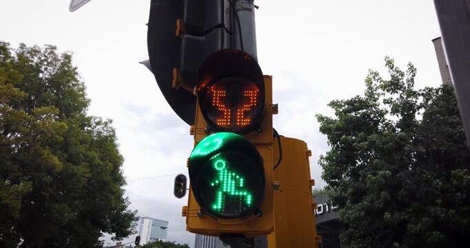 Cinematic static view of a pedestrian crossing signal in Polanco, Mexico City, showing the countdown reaching zero before the stop phase under an overcast midday sky.